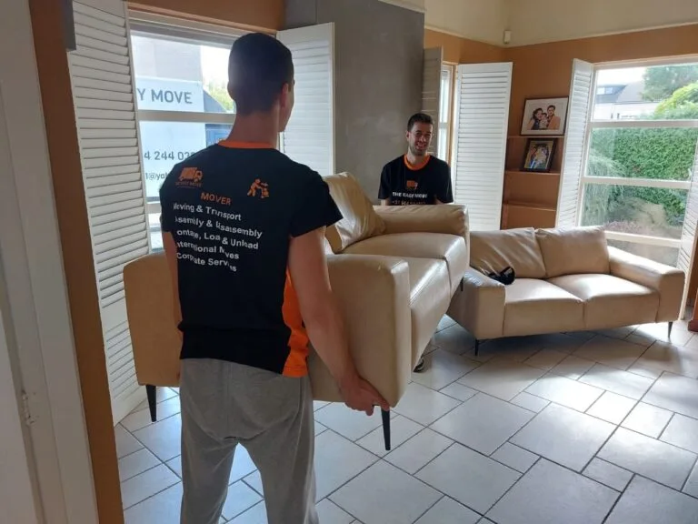 Friendly movers in Ostend lifting a sofa